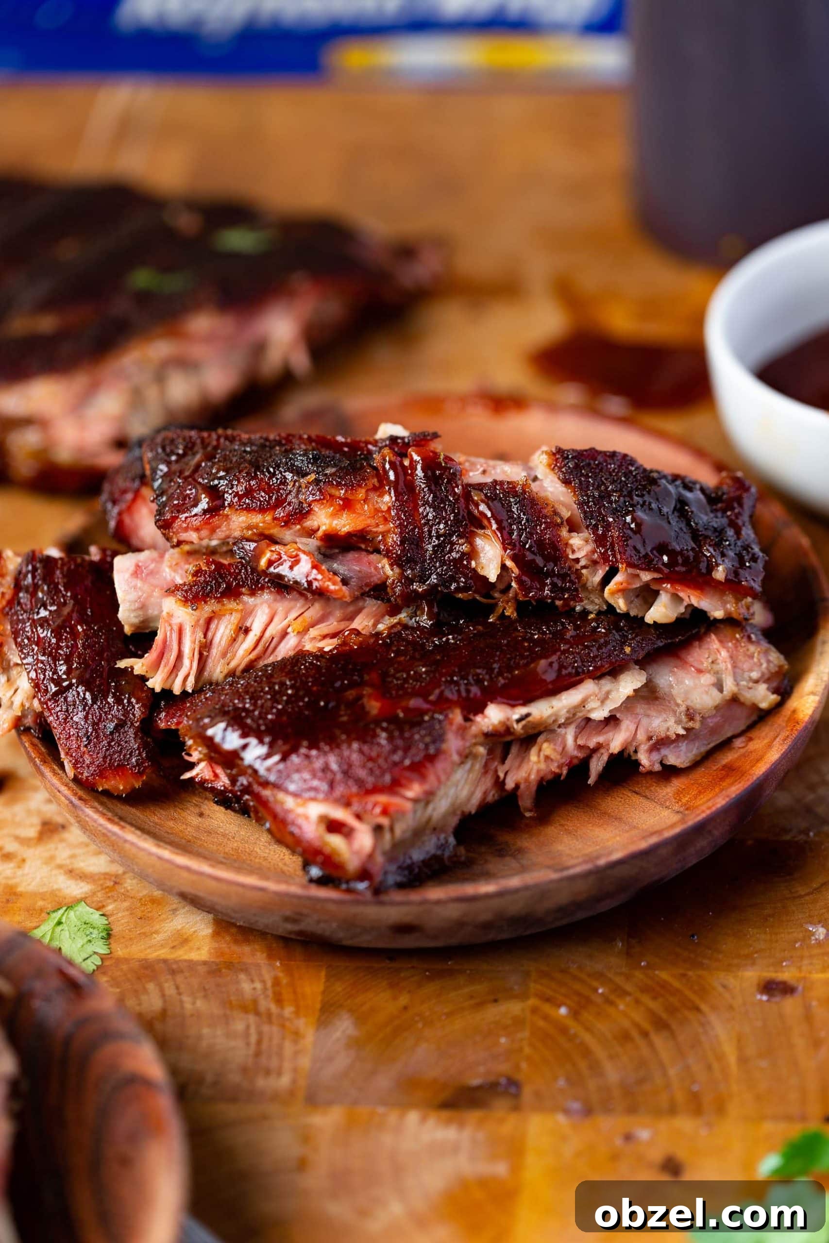 Easy BBQ Spare Ribs a photo of a wooden plate piled high with juicy grilled ribs