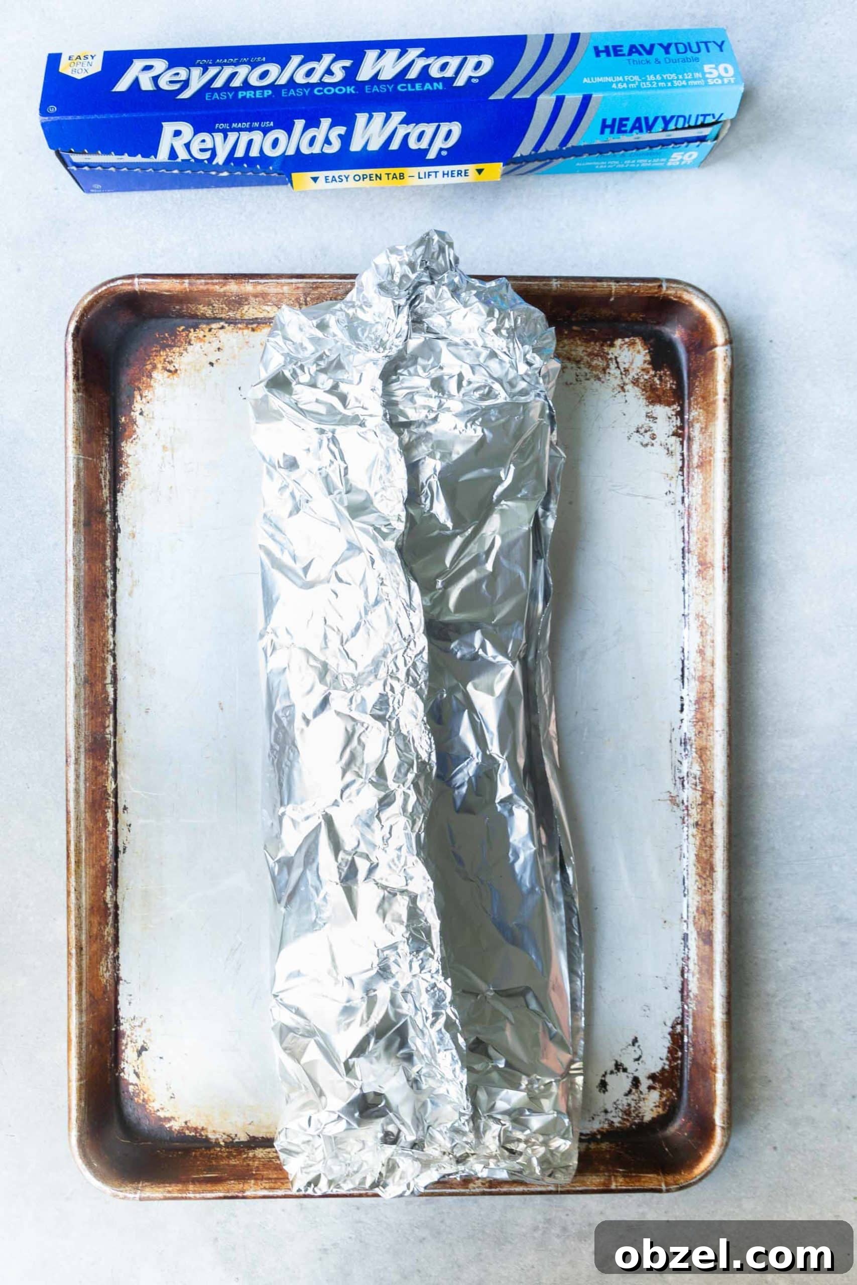 Easy BBQ Ribs a photo of a baking sheet with a rack of ribs wrapped in foil on it