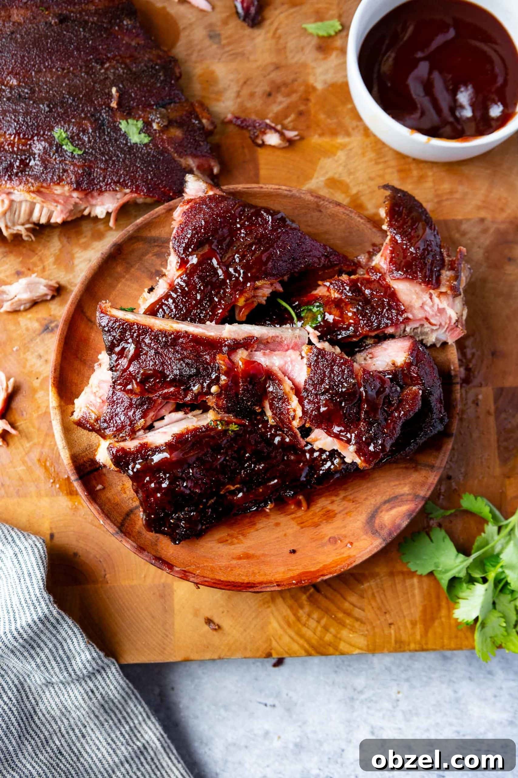 Easy BBQ Spare Ribs a photo of a wooden plate on a wooden table filled with grilled ribs