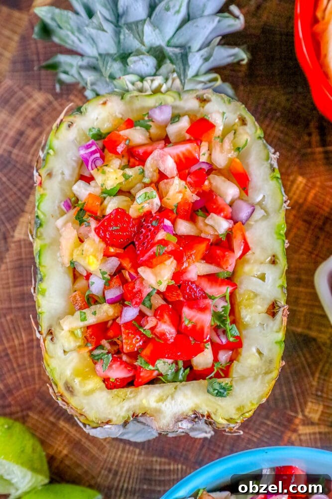Fresh Pineapple Strawberry Salsa Recipe 3 Pineapple strawberry salsa in a hollowed-out pineapple on a wooden board