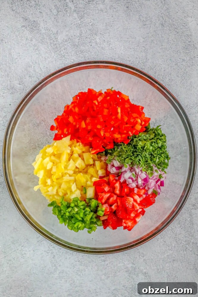 Fresh Pineapple Strawberry Salsa Recipe 6 Diced pineapple, jalapeno, strawberries, onion, cilantro, lime, and bell pepper in a clear bowl