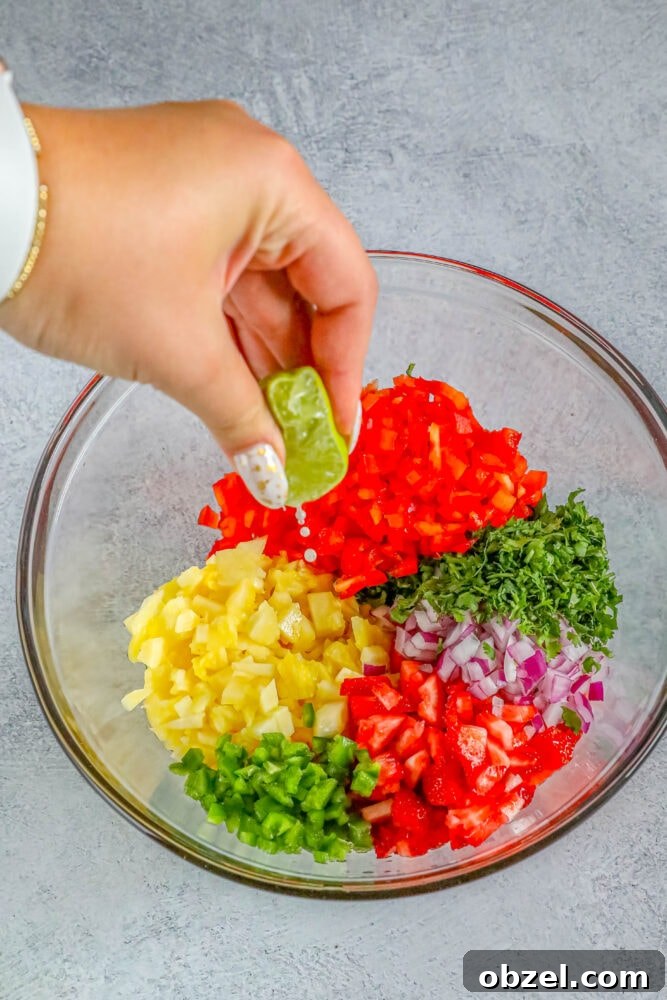 Fresh Pineapple Strawberry Salsa Recipe 7 Lime being squeezed over pineapple strawberry salsa ingredients