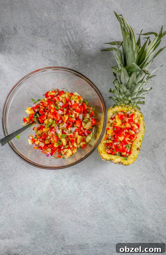 Fresh Pineapple Strawberry Salsa Recipe 9 Pineapple strawberry salsa being spooned into a hollowed-out pineapple
