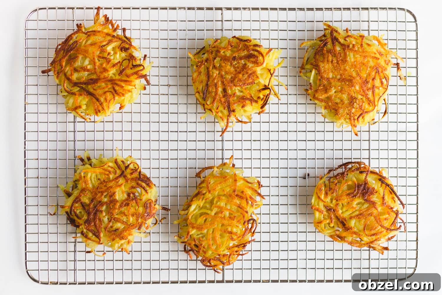 Rosti Eggs Benedict with Crispy Potato Pancakes 4 Overhead shot of 6 rosti on a metal cooling rack