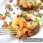 A fork cutting into Rosti Eggs Benny on a white plate garnished with chopped bacon and chives.