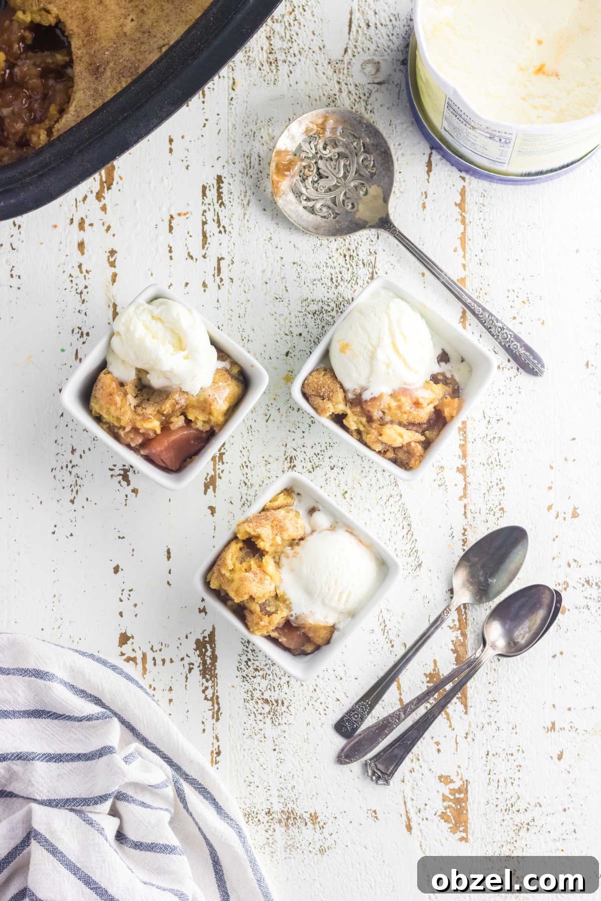 Slow Cooker Caramel Apple Dump Cake Recipe 2 Overhead view of three servings of caramel apple dump cake with ice cream.