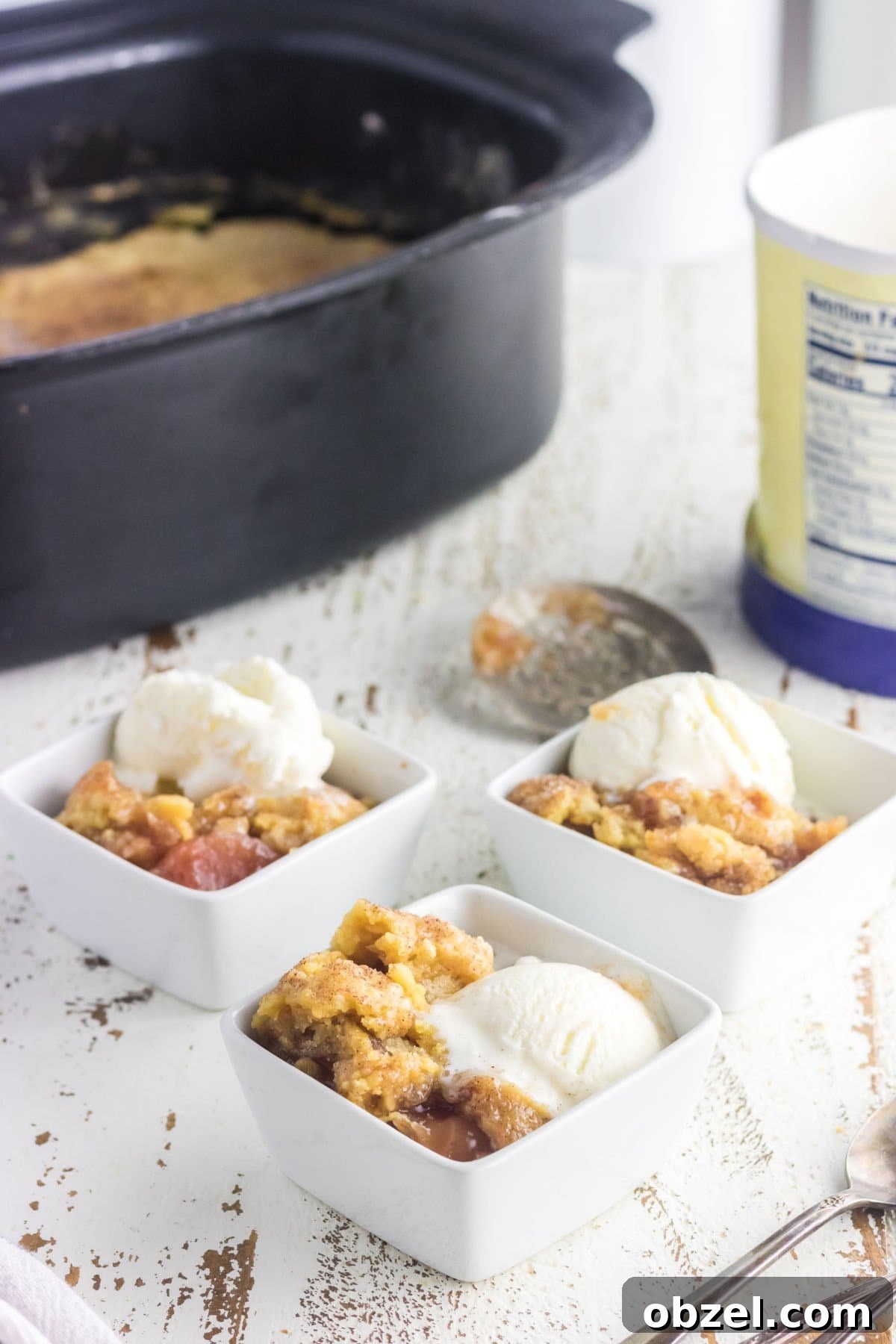 Slow Cooker Caramel Apple Dump Cake Recipe 7 3 servings of dump cake in bowls with ice cream.