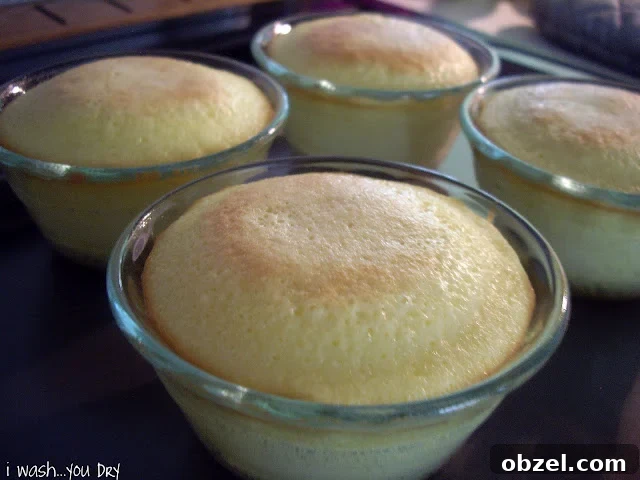 Mini baked cakes in glass dishes on a baking sheet.