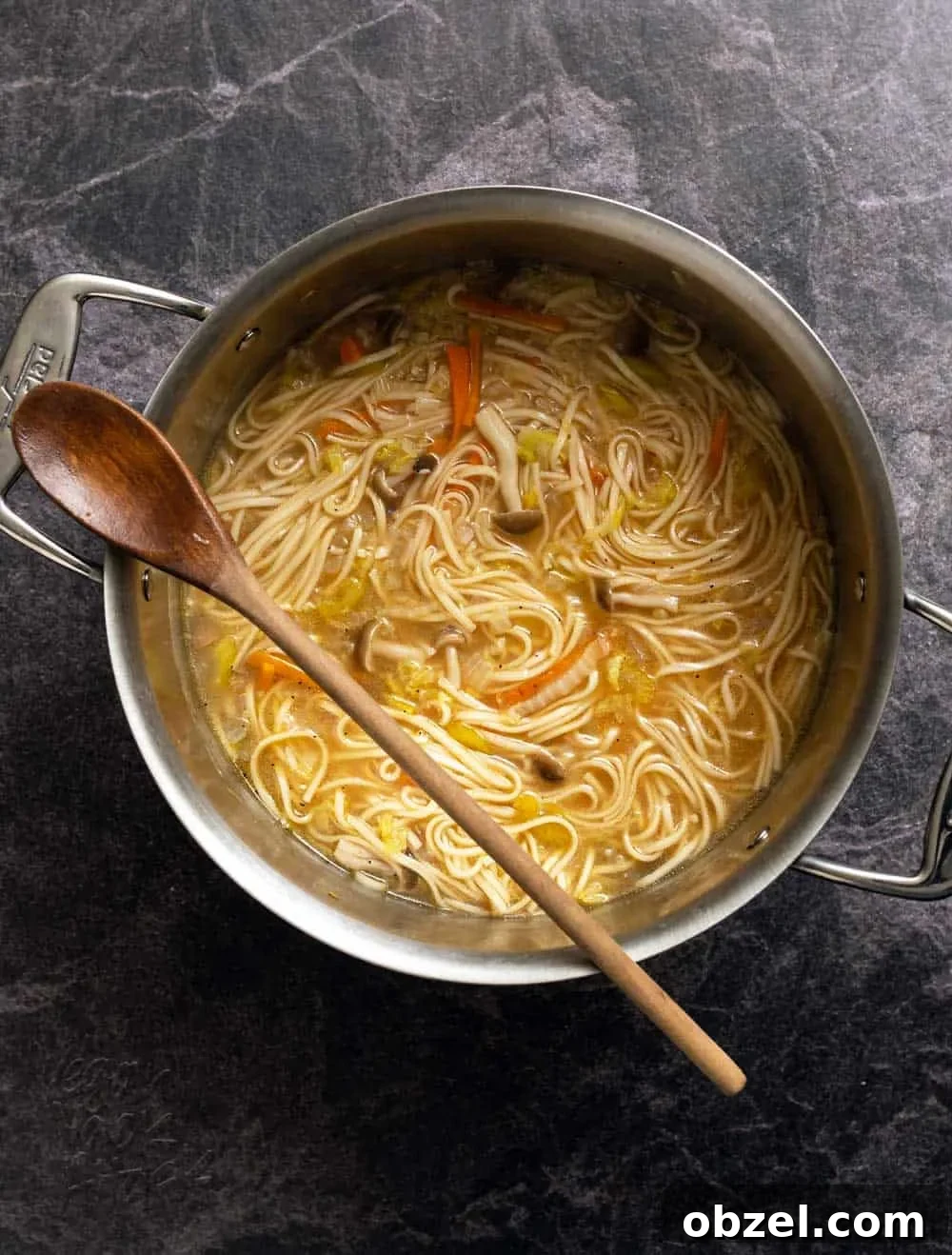Spicy Vegan Udon Noodle Soup Recipe 9 Noodle soup in a large metal pot with wooden spoon
