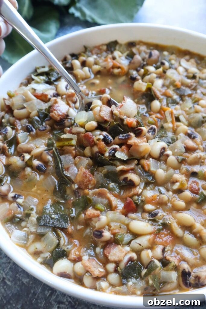 white bowl with spoon scooping up cooked black eyed peas.