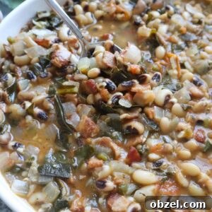 white bowl with spoon scooping up cooked black eyed peas.