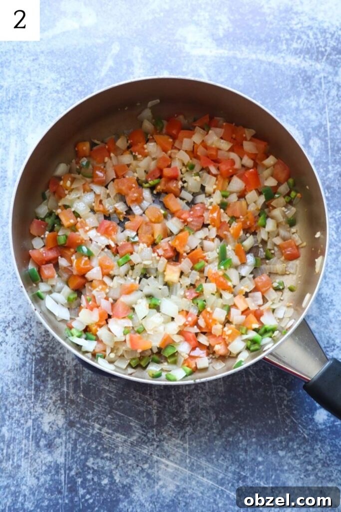 skillet with sauteed garlic onion, jalapeno, and tomatoes.
