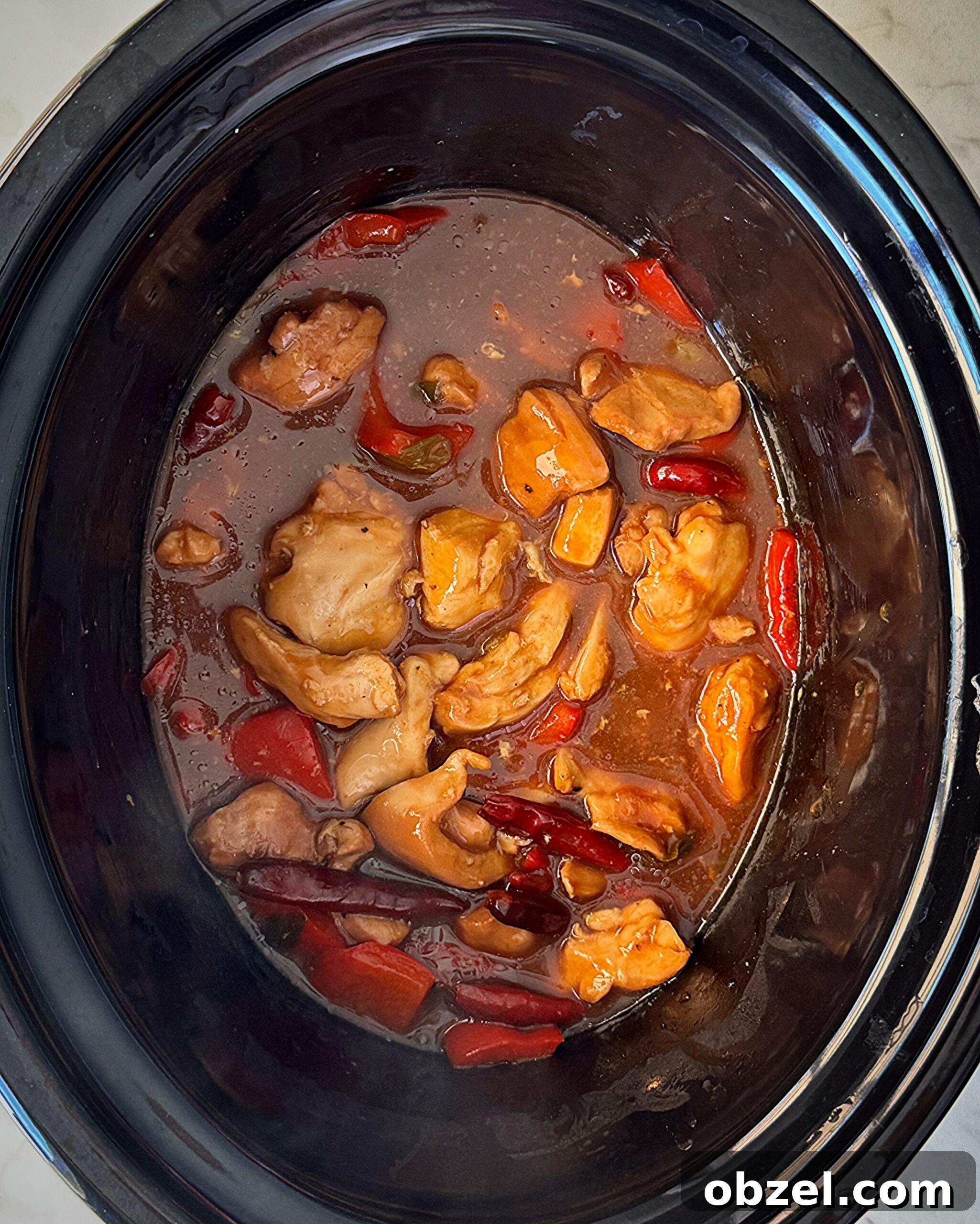 overhead shot of cooked Kung Pao Chicken (Panda Express Copycat) in a black slow cooker
