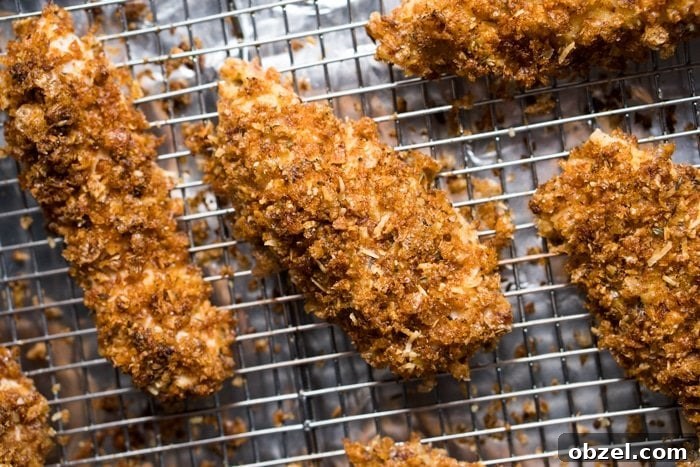 Freshly coated unbaked keto chicken tender on a rack
