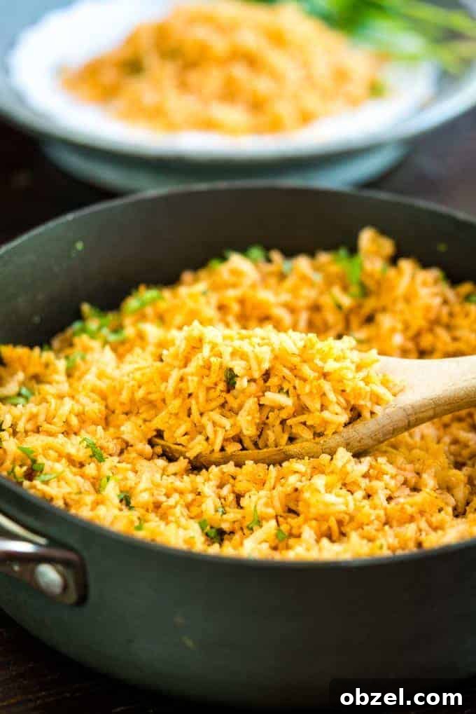 Spanish Rice Recipe with Tomatoes and Garlic 2 Mexican Rice with a wooden spoon