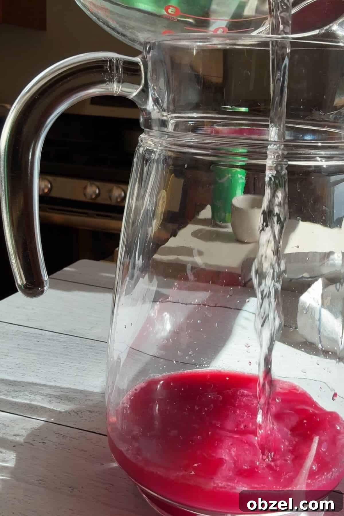 Pouring water into blueberry simple syrup and lemon juice.