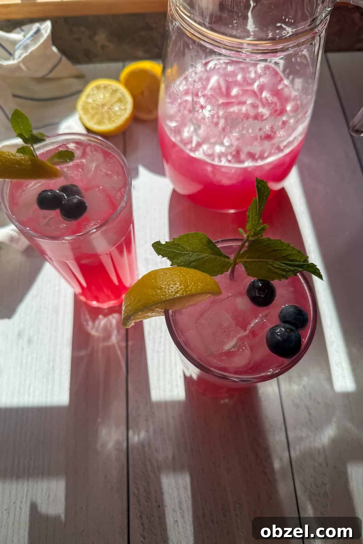 An overhead shot of glasses filled with ice and lemonade garnished with blueberries.