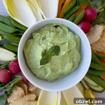 Close up of creamy basil and avocado dip in a white bowl.