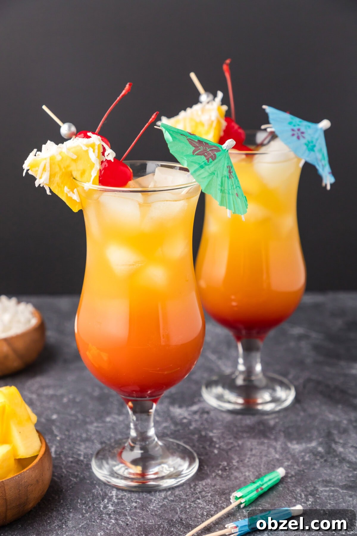 Malibu Sunset: Where to Watch, Photograph and Enjoy 2 Two Malibu Sunset cocktails garnished with a pineapple wedge, cherry and umbrella