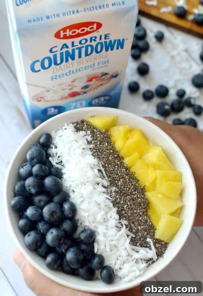 Banana pineapple smoothie bowl topped with fruit and chia seeds