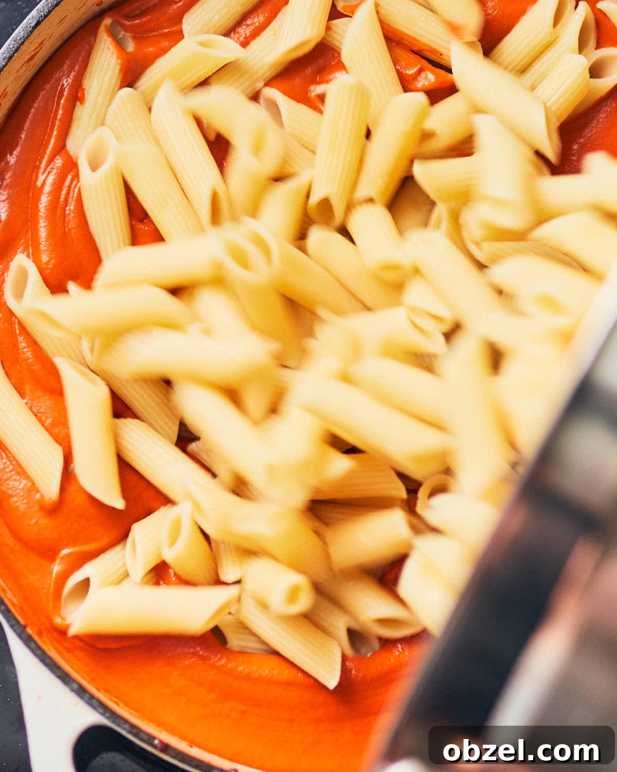 Creamy Vegan Vodka Sauce Pasta 13 Cooked pasta being added to a pan of vegan vodka sauce