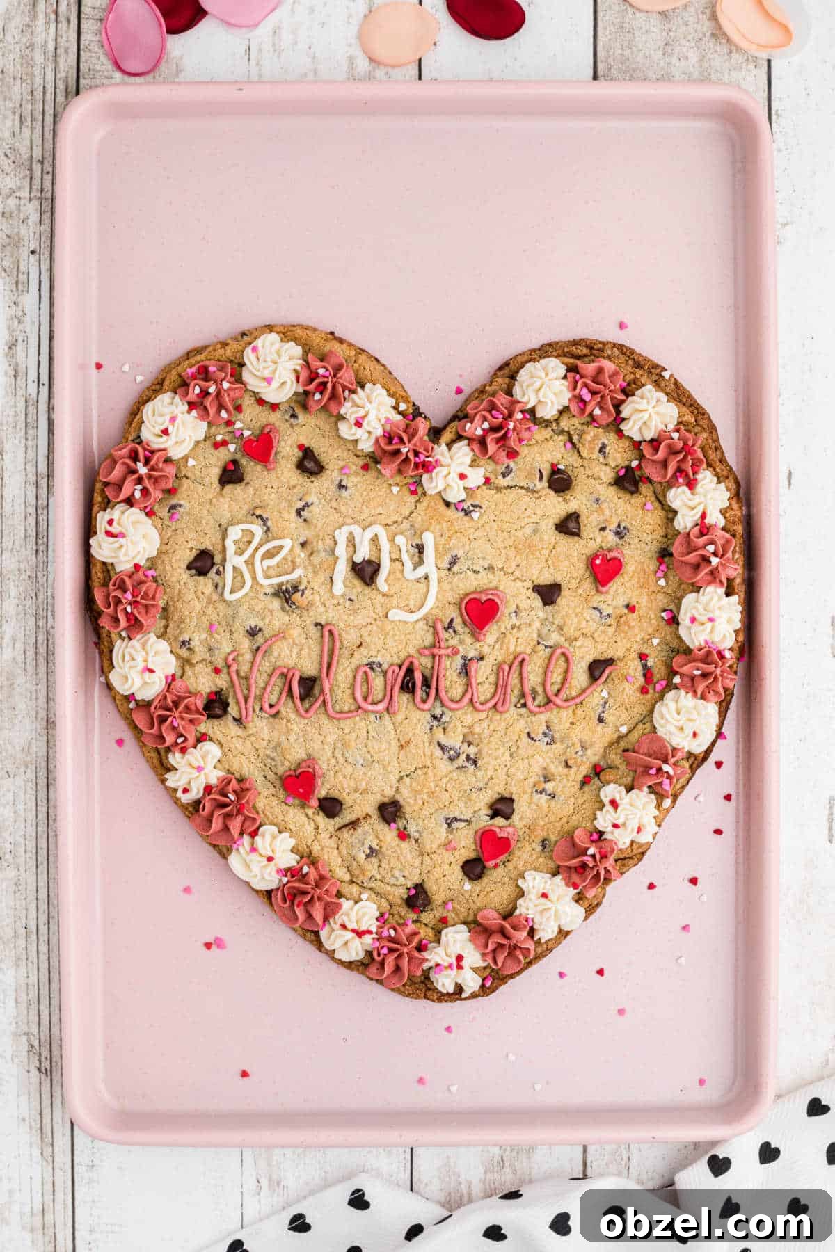 An overhead shot of a giant valentines cookie on a baking sheet.