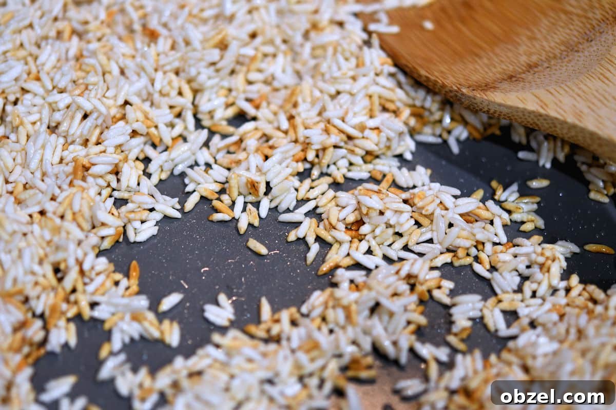 Homemade Mexican Red Rice Recipe 12 Skillet with sauteed white rice and a wooden spoon.